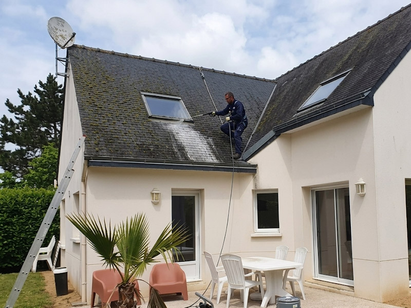 Artisan couvreur appliquant un traitement de démoussage et hydrofuge sur un toit pavillonnaire à Izon
